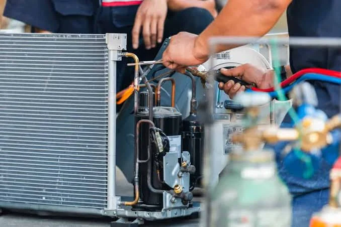 Close-up of repair work on an open outdoor HVAC unit